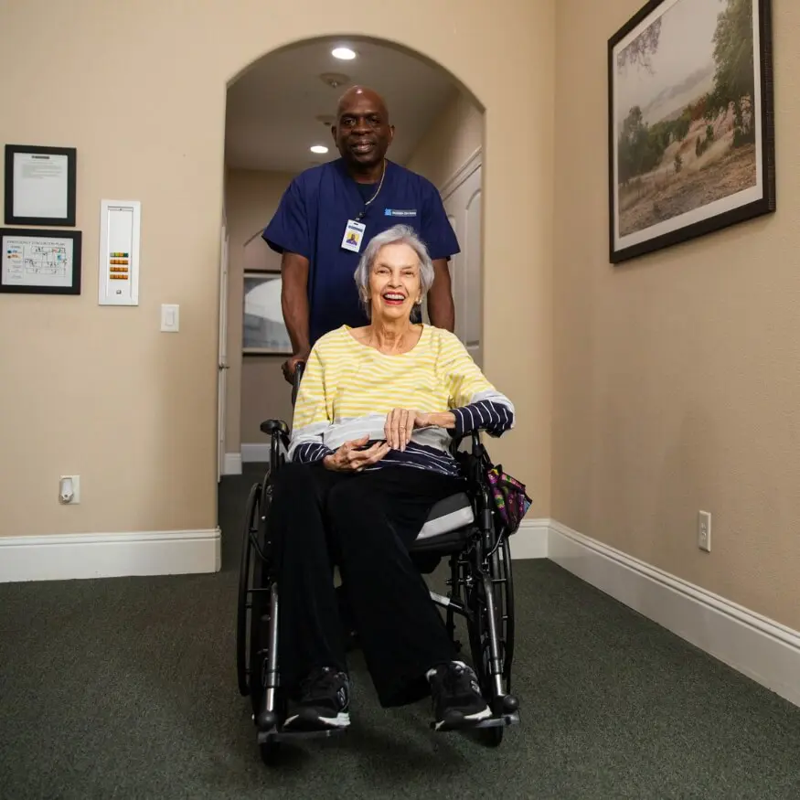 elderly woman in wheelchair with caregiver