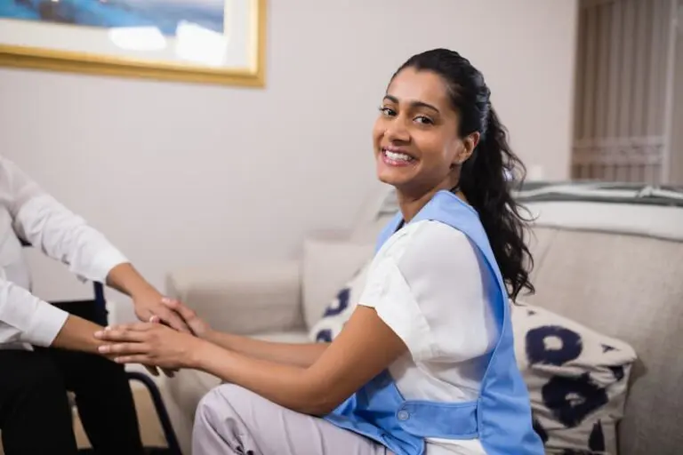 Caring Woman Smiling While Holding Hands with Patient