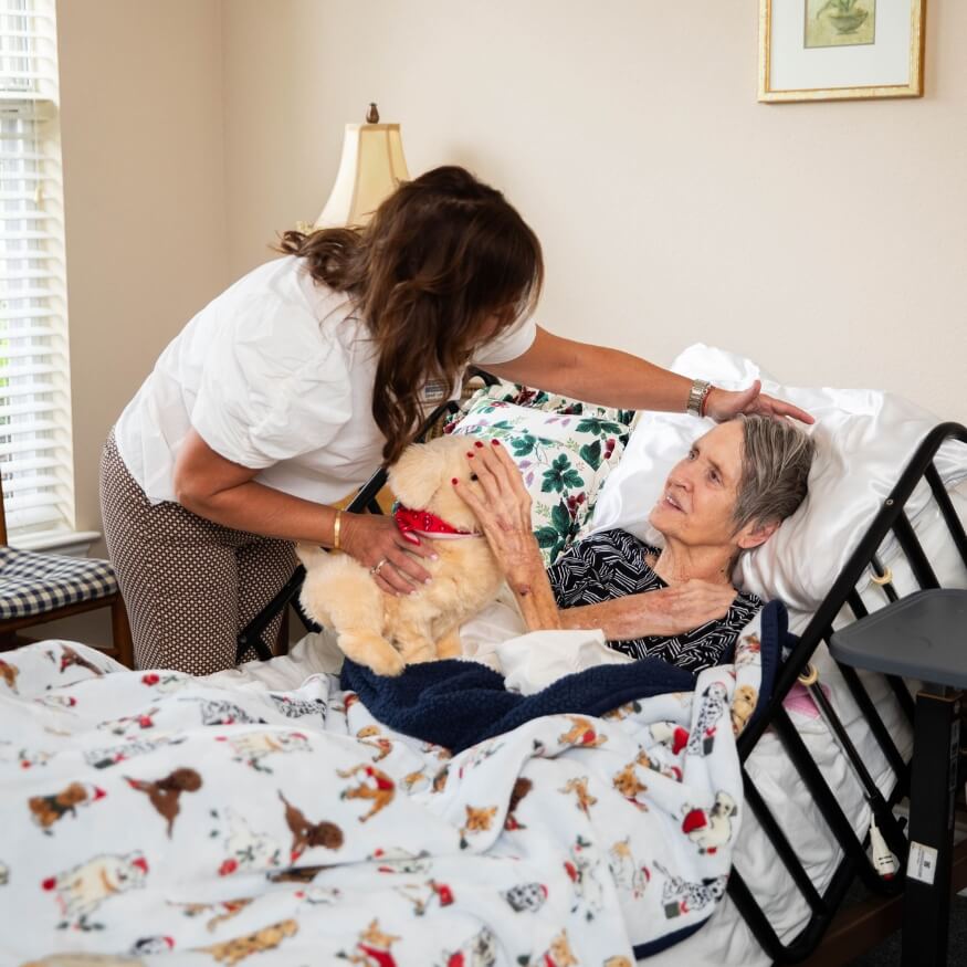 caregiver giving elderly woman stuffed animal