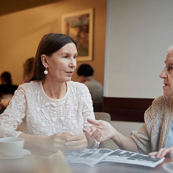 young and old woman chatting in cafe
