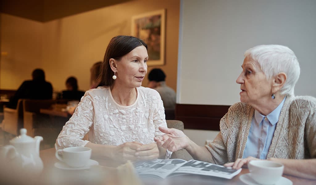 young and old woman chatting in cafe