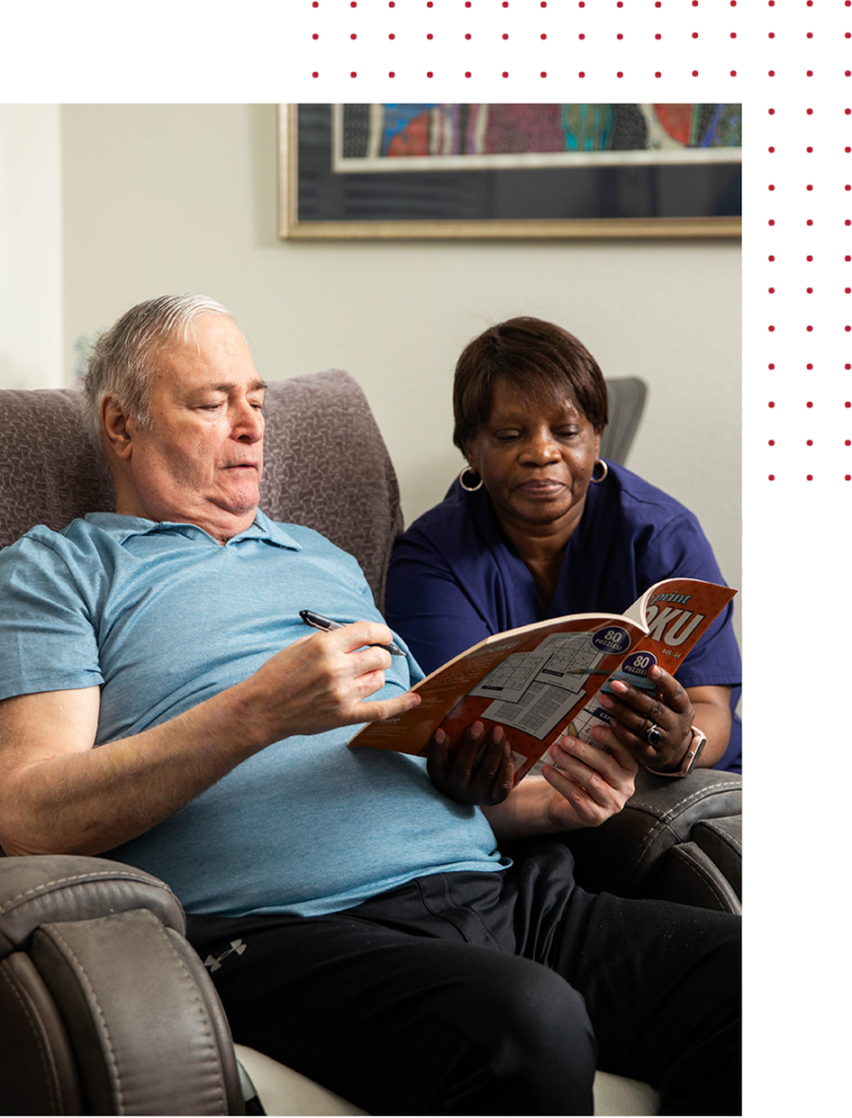 Elderly man and caregiver doing Sudoku