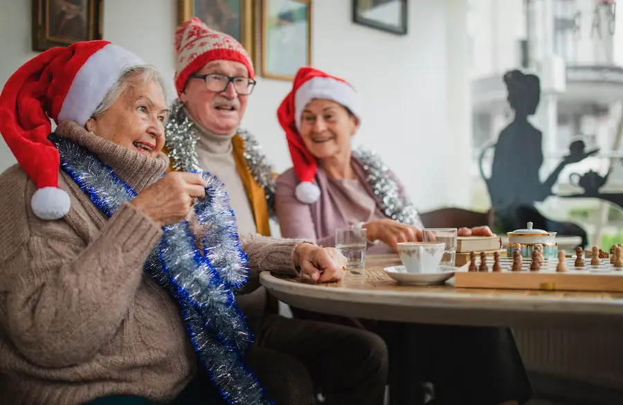 happy senior friends sitting indoors in community