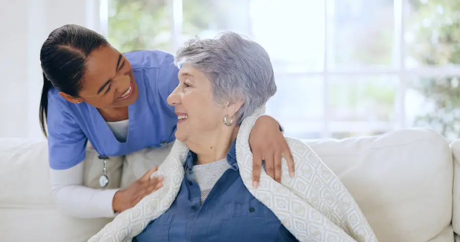 Smiling Caregiver with Senior Woman in Living Room